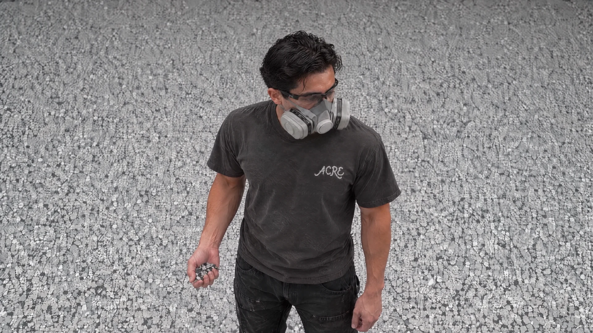 Acre installer holding Domino flakes on a freshly broadcast floor